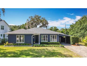 Charming single-story home featuring a blue exterior, well-manicured lawn and covered carport at 1202 Chichester St, Orlando, FL 32803