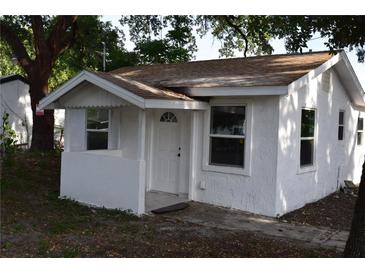 Charming single-story home featuring white stucco and a welcoming covered porch, perfect for enjoying quiet moments at 1518 Indiana St, Orlando, FL 32805
