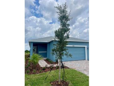 Charming single-story home with blue siding, an attached garage and a neatly landscaped front yard at 1912 Diamond Head Cir, Lake Hamilton, FL 33851