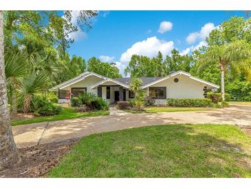 Well-maintained single-story home with lush landscaping and a circular driveway at 2108 Silver Leaf Ct, Longwood, FL 32779