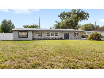 Charming single-story home featuring a stone facade, well-kept lawn, and freshly painted trim at 4604 S Shore Rd, Orlando, FL 32839