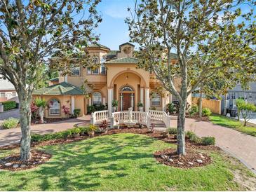 Stunning two-story home with a beautiful lawn, brick driveway and exquisite water fountain at 7957 S Park Pl, Orlando, FL 32819
