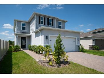 Charming two-story home featuring a two-car garage, well-maintained lawn, and inviting curb appeal at 16301 Sanctuary Reserve Loop, Clermont, FL 34714