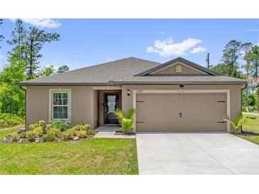 Charming single-story home featuring a manicured lawn, neutral exterior paint, and a two-car garage at 1898 9Th Ave, Deland, FL 32724