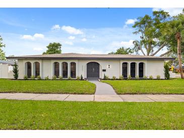 Stunning single story home featuring an arched doorway and manicured front yard landscaping at 2327 Fieldingwood Rd, Maitland, FL 32751