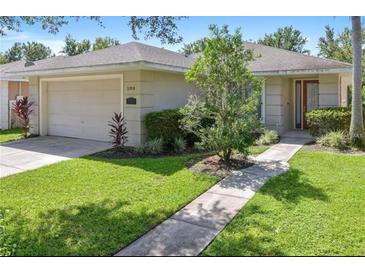 Charming single-story home featuring manicured lawn, mature landscaping, and a two-car garage at 2918 Sunset Vista Blvd, Kissimmee, FL 34747
