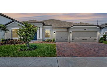 Charming single-story home featuring a well-manicured lawn, brick driveway, and a classic architectural design at 3332 Lone Cypress Pt, Oviedo, FL 32765