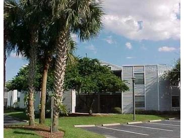 Condo community with mature palm trees and well-maintained landscaping on a sunny day at 3807 Atrium Dr, Orlando, FL 32822