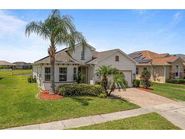 Inviting single-Gathering home showcasing well-manicured lawn and mature palm trees adding curb appeal at 4469 Biscayne Breeze Way, Kissimmee, FL 34744