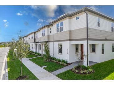 Charming townhome exterior featuring neutral tones, manicured landscaping, and a welcoming walkway to the front door at 4830 Prairie Preserve Run, St Cloud, FL 34772