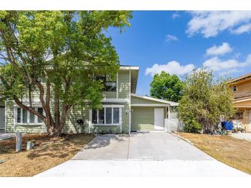 Charming two-story home with green siding, a concrete driveway, and mature trees in the front yard at 522 Boxelder Ave, Altamonte Springs, FL 32714