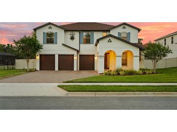 Beautiful two-story home with a three-car garage, arched entryway, and well-maintained lawn at 675 Primrose Willow Way, Apopka, FL 32712