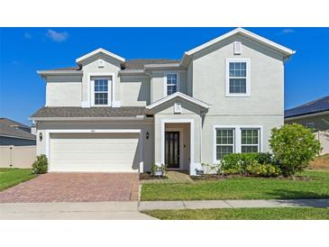 Charming two-story home boasts a well-manicured lawn and an attached two-car garage at 683 Campo Ln, Davenport, FL 33837