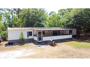 Charming single-story home with a covered porch and lush landscaping at 736 Guy Rd, Orlando, FL 32828