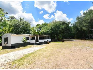Single-story home featuring a long driveway and a large, tree-filled lot at 736 Guy Rd, Orlando, FL 32828