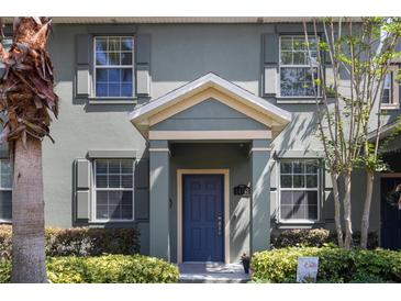 Charming home exterior features a blue front door, gray shutters, and neatly trimmed landscaping at 14743 Driftwater Dr, Winter Garden, FL 34787