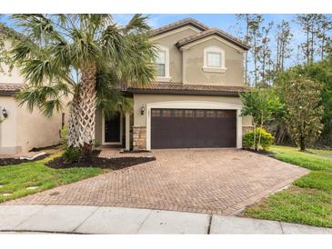 Inviting two-story home with brick driveway, two car garage, and lush landscaping at 1801 Nice Ct, Kissimmee, FL 34747