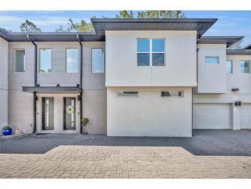 Contemporary townhome featuring a textured gray brick facade and a well-maintained paved driveway at 2162 Lake Howell Preserve Ct, Maitland, FL 32751