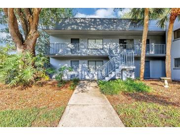 Condo exterior featuring stairs leading to second floor units and sidewalk up to units at 2301 Oak Park Way # 101, Orlando, FL 32822