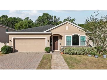 Charming single-story home featuring a brick driveway, a welcoming front porch and manicured landscaping at 34423 Alameda Dr, Sorrento, FL 32776