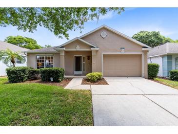 Charming single-story home with a well-manicured lawn and a two car garage at 3661 Kingswood Ct, Clermont, FL 34711