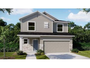 Charming two-story home with gray siding, stone accents, and a two-car garage at 3880 Bluethread Way, Poinciana, FL 34759