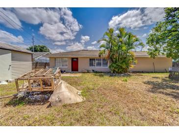 Single-story home with a red door and a neglected lawn, under a cloudy sky at 409 Lake Ned Rd, Winter Haven, FL 33884