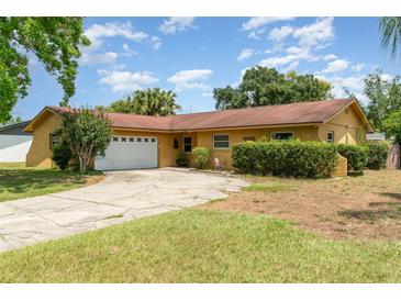 Charming single-story home featuring a two-car garage, mature landscaping, and a well-maintained lawn at 5001 Tangerine Ave, Winter Park, FL 32792