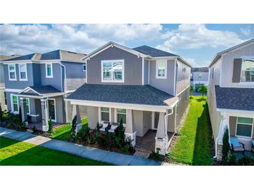 Beautiful two-story home featuring a covered front porch, neutral colors, and well-maintained landscaping at 635 Cheval Ln, Debary, FL 32713