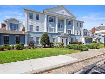 Beautiful three-story building with white columns and blue accents at 7689 Heritage Crossing Way # 202, Reunion, FL 34747