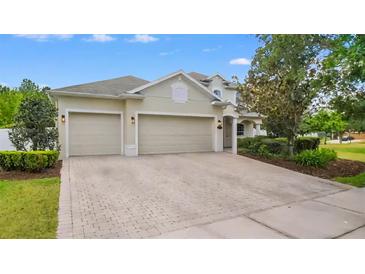 Charming home featuring a paved driveway leading to a two-car garage and manicured landscaping at 955 Holly Springs Ter, Oviedo, FL 32765