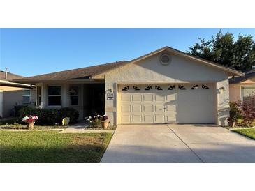 Charming single-story home with a well-manicured lawn, two-car garage and lovely curb appeal on a sunny day at 2244 Silver Lakes N Dr, Lakeland, FL 33810