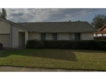 Single-story home featuring brick accents, a well-maintained lawn, and mature landscaping at 2342 Cilantro Dr, Orlando, FL 32837