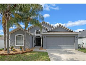 Charming single-story home with a two-car garage, well-maintained lawn, and lovely palm trees at 2407 Oakington St, Winter Garden, FL 34787