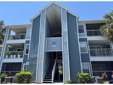 Exterior view of a blue and gray two-story building with an open stairwell and balconies at 2516 Grassy Point Dr # 210, Lake Mary, FL 32746