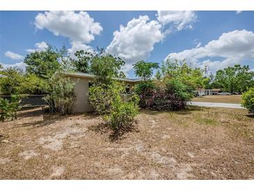 Modest home featuring a neutral-toned exterior and mature landscaping under a partly cloudy sky at 3025 Bon Air Dr, Orlando, FL 32818