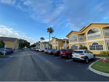Street view of colorful condos with a parking lot and palm trees at 3147 Britannia Blvd # A, Kissimmee, FL 34747