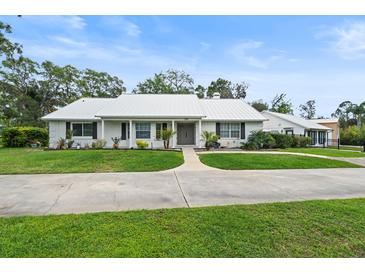 Charming one-story home featuring a metal roof, well-manicured lawn, and a welcoming driveway at 335 Debary Ave, Debary, FL 32713