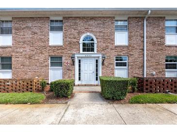 Charming brick building featuring a white door with an arched transom window and manicured landscaping at 4332 Lake Underhill Rd # 12D10, Orlando, FL 32803