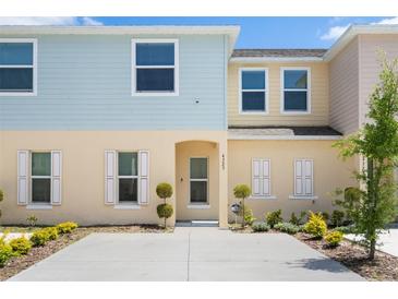 Charming two-story townhome with colorful siding and well-manicured landscaping at 4725 Coral Castle Dr, Kissimmee, FL 34746