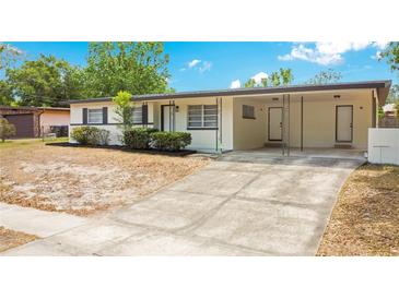 Charming single story home featuring updated black shutters, a large driveway, and covered porch at 6820 Ambassador Dr, Orlando, FL 32818
