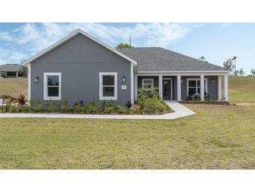 Charming single-story home with a well-manicured lawn and inviting front porch at 72 Fairway Cir, Umatilla, FL 32784