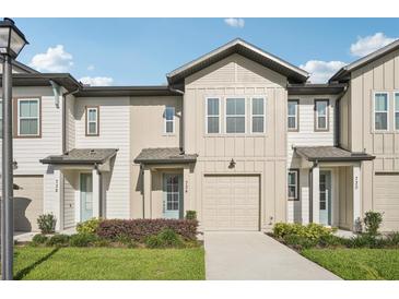 Charming townhome showcasing a well-manicured lawn and an attached single-car garage at 734 Longboat Dr, Davenport, FL 33896
