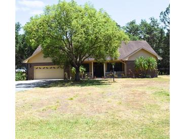 Traditional-style home with a large shade tree and a well-manicured lawn at 859 Morning Star Dr, Lakeland, FL 33810