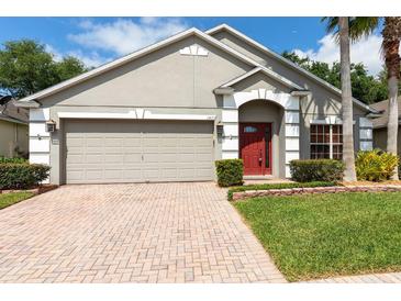 Charming single-story home featuring a brick driveway, well-kept lawn, and attached two-car garage at 1457 Waukon Cir, Casselberry, FL 32707