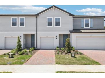 Charming townhomes feature attached garages, neatly landscaped yards and light-colored exterior paint at 16391 Bird Of Paradise Ave, Clermont, FL 34714