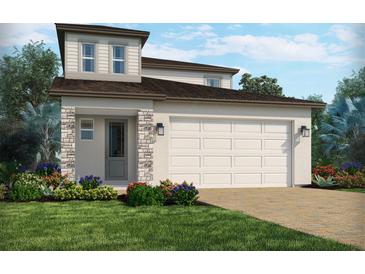 Charming two-story home featuring a neutral color scheme, brick accents, an attached garage, and a well-manicured front lawn at 1904 Archer Dr, Minneola, FL 34715