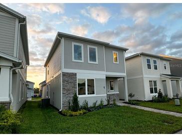 Charming two-story home featuring stone accents and well-manicured landscaping under a beautiful sky at 1999 Iorio St, St Cloud, FL 34771