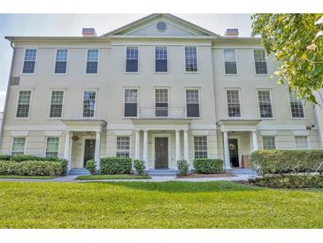 Elegant townhouse featuring a well-manicured lawn and classic architectural details at 312 Grand Bay Ln, Celebration, FL 34747