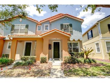 Charming townhome with a colorful exterior, manicured landscaping, and a welcoming front entrance at 7348 Yoder St, Windermere, FL 34786